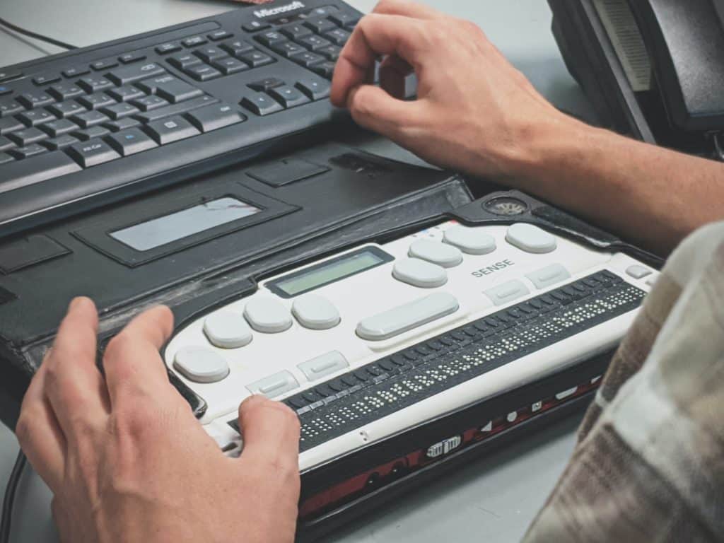 A person operating a braille writer sits at a desk in front of a keyboard.

Photo by Sigmund 